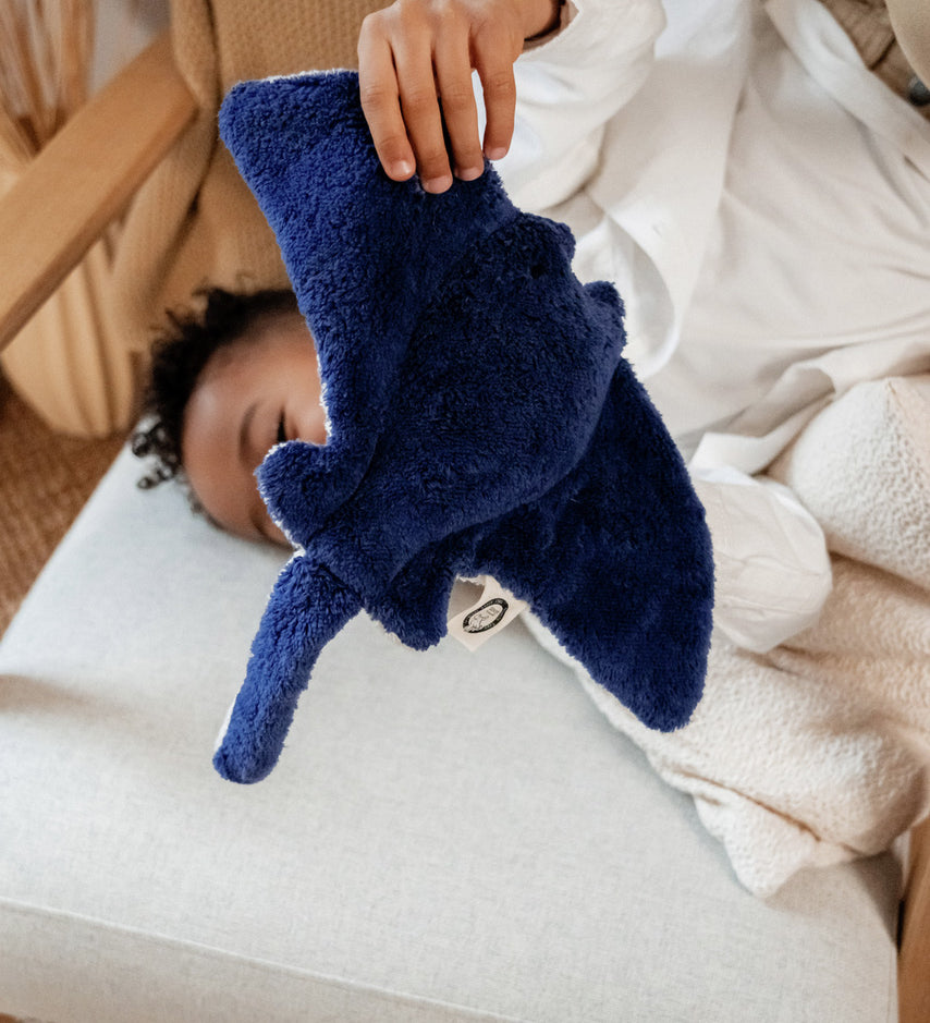 The Senger small cuddly manta Ray stuffed organic toy, being held by a toddler