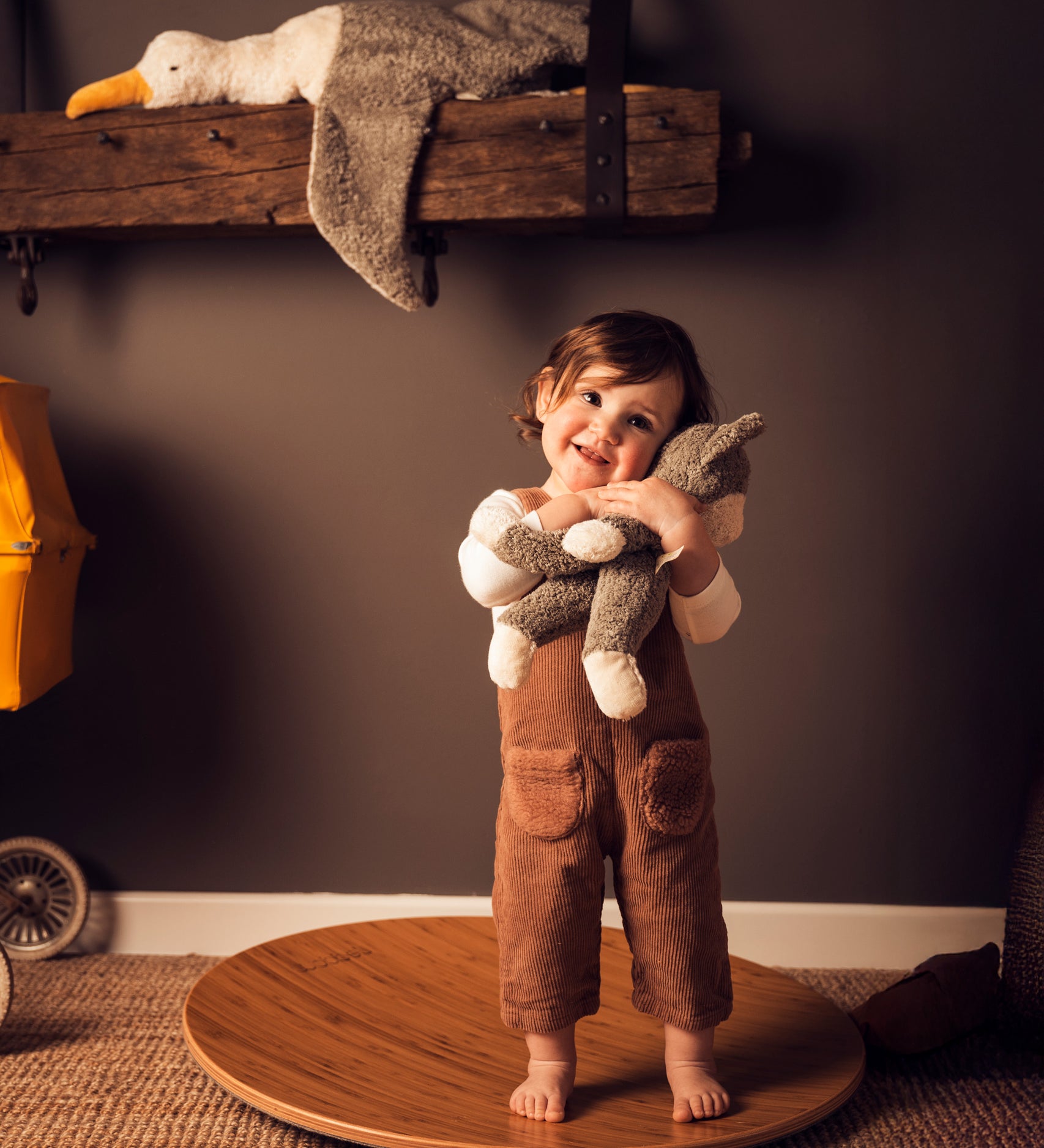 A child standing on a Wobbel 360 cuddling a Senger Small Floppy Cat.