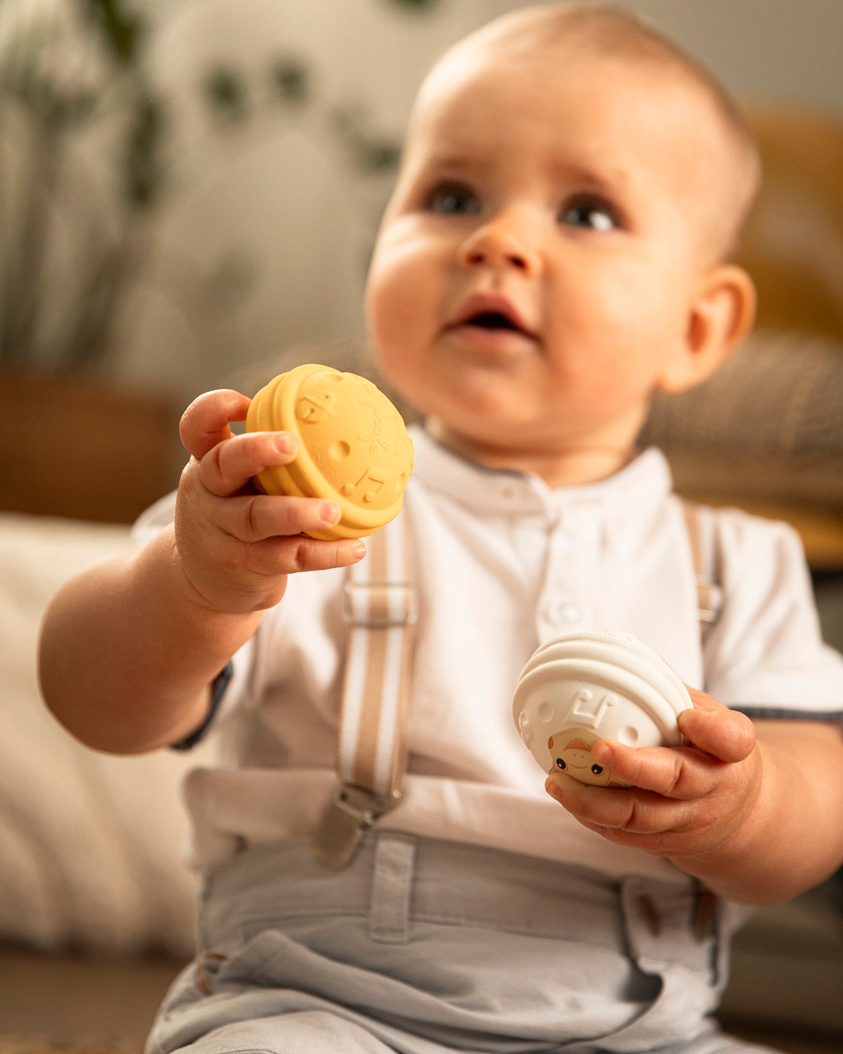 looking down and engaging with the Sophie The Giraffe - Once Upon A Time 5 Senses Musical Balls set