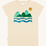 Silverstick Habitats Organic T-Shirt in the cream coloured Angora colourway. The front of the t-shirt features a mountain and sea graphic with a sun.
