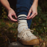 A close up of a person wearing a Silverstick Organic Cotton Air sports Sock with off white colured canvas shoes.