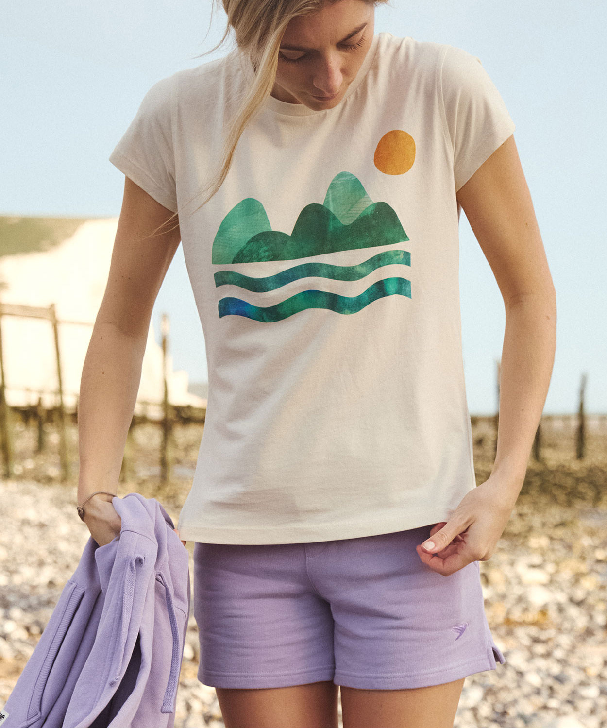 A woman wearing the Silverstick Habitats Organic T-Shirt in the Angora colourway.