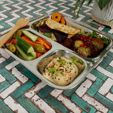 A Slice Of Green Stainless Steel Divided Plate. The plate has hummus in the smallest section, carrot, cucumber and olives in the middle section and flatbread, salad and falafels in the biggest section. This stainless steel plate is suitable for snacks and meals and perfect for children and adults.