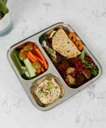 A Slice Of Green Stainless Steel Divided Plate. The plate has hummus in the smallest section, carrot, cucumber and olives in the middle section and flatbread, salad and falafels in the biggest section. This stainless steel plate is suitable for snacks and meals and perfect for children and adults.