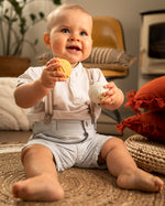 A child happily playing and holding the yellow and white musical balls from the Sophie The Giraffe - Once Upon A Time 5 Senses Musical Balls set