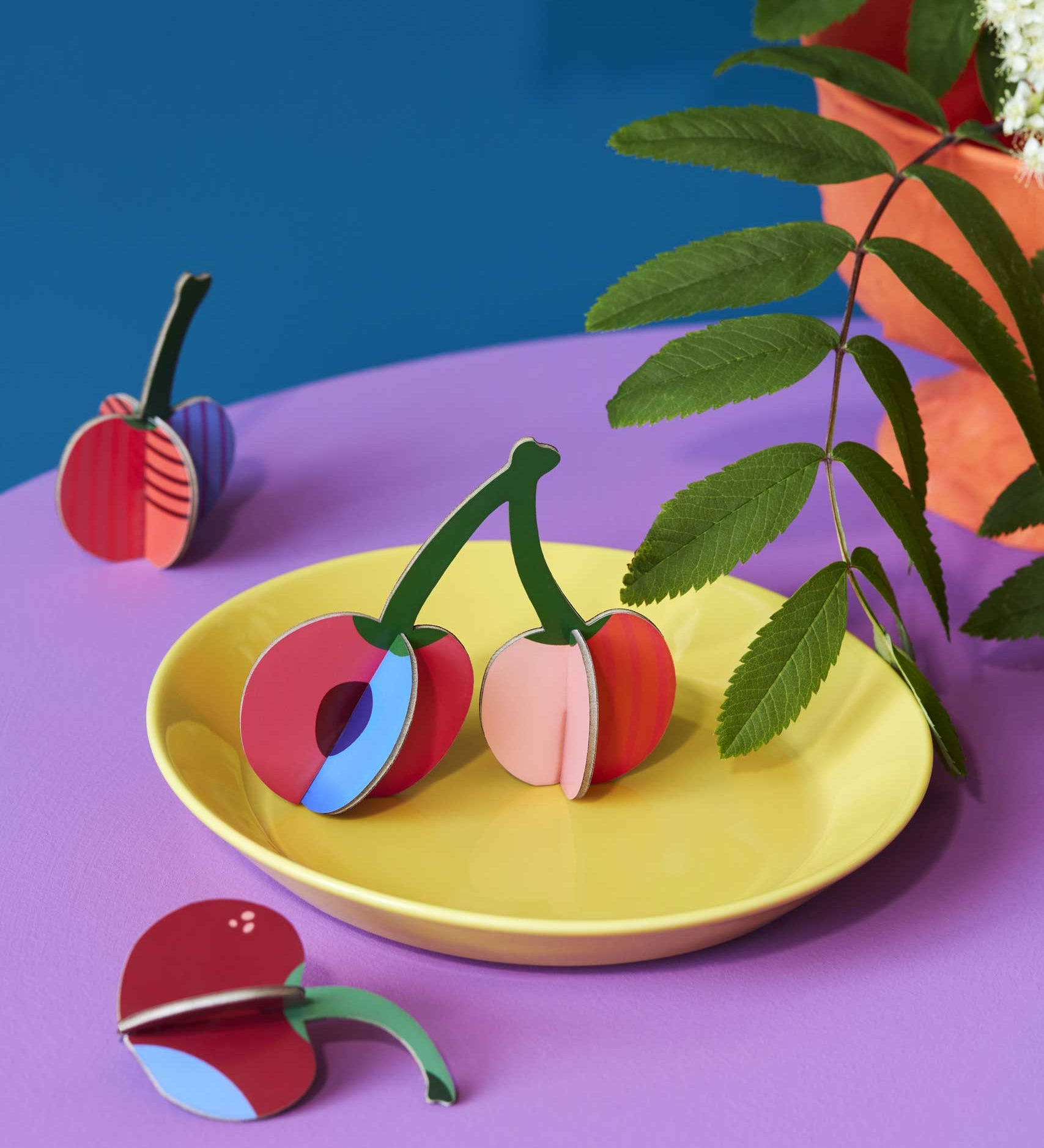 Studio Roof 3D Pop Out Card Cherries. The cherry decorations have been placed on a yellow plate. This 3D pop out card DIY kit is part of Studio Roof's fruits  collection which is available at Babipur.