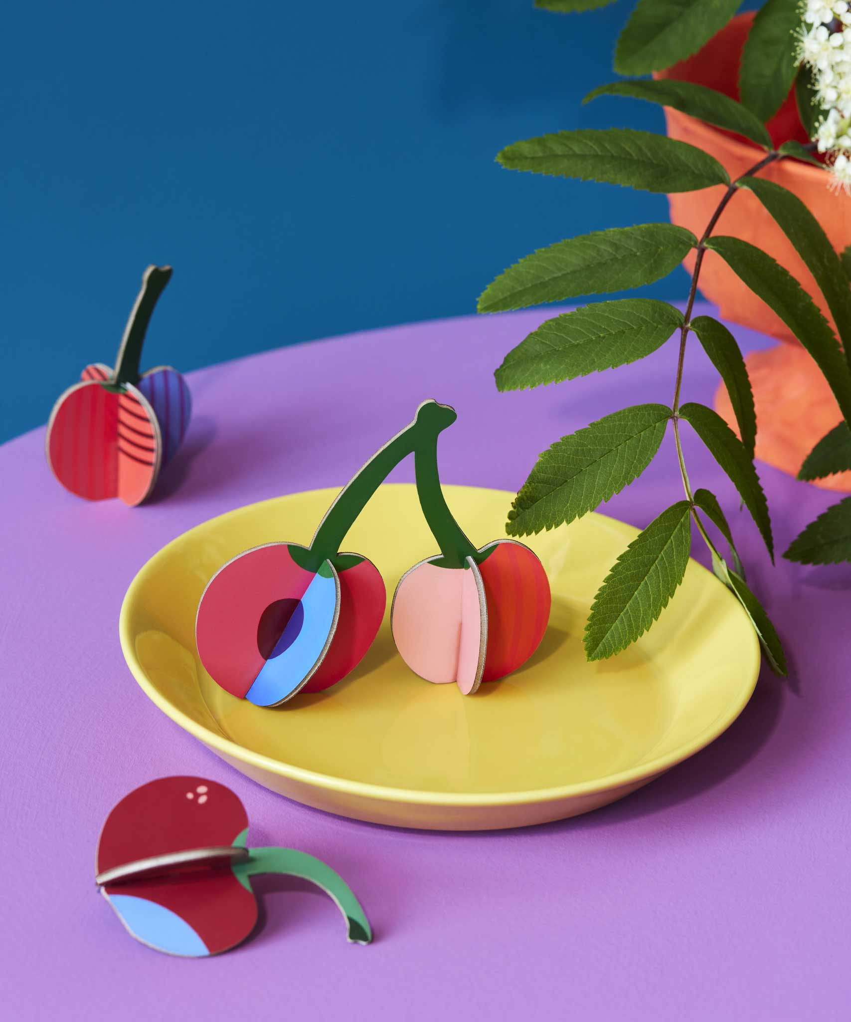 Studio Roof 3D Pop Out Card Cherries. The cherry decorations have been placed on a yellow plate. This 3D pop out card DIY kit is part of Studio Roof's fruits  collection which is available at Babipur.