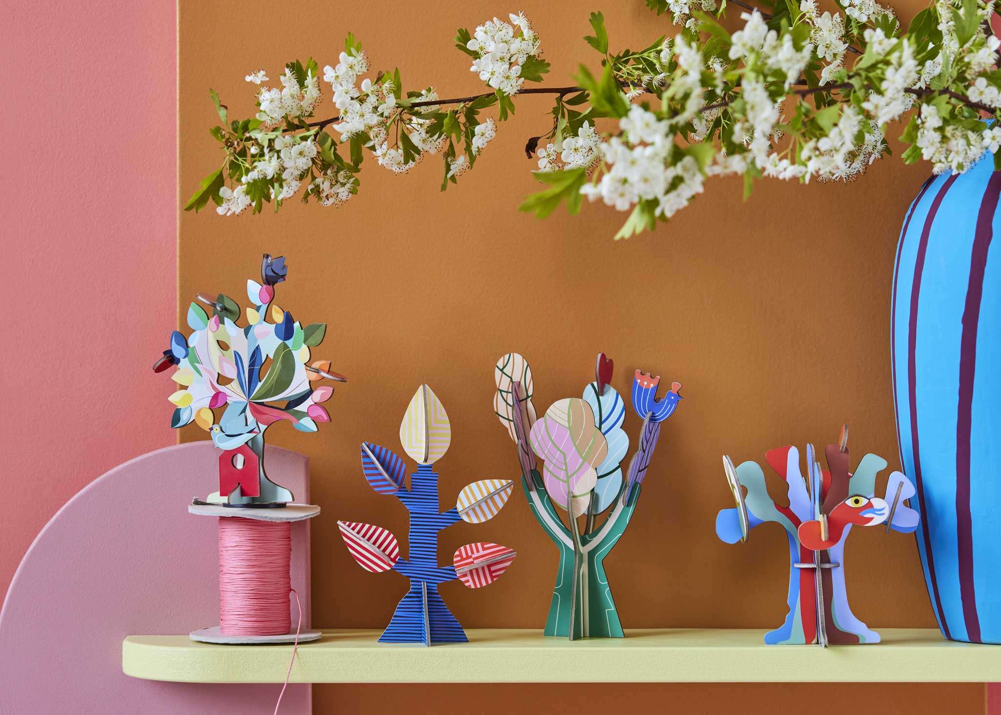Studio Roof 3D Pop Out Card decorations placed on a shelf. These cardboard DIY craft kits come with a card. This kit is part of a wide range of Studio Roof kits that are available at Babipur.