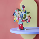 The Studio Roof 3D Pop Out Card Dream Tree on a purple shelf. A 3D cardboard DIY craft kit tree with different coloured leaves. This kit is part of a wide range of Studio Roof kits that are available at Babipur.