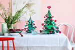 with a larger cardboard Christmas tree and a squirrel on the right on a white tale