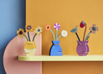 Three different Studio Roof 3D flowerr Pop Out Cards placed on a shelf. These 3D pop out card bouquet is part of Studio Roof's artist collection which is available at Babipur.