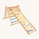Triclimb wooden folding pikler climbing frame with pastel themed rungs including purple blue, green, yellow, orange and pink. Showing the Triclimb Miri slide hooked on a rung and the sticks in matching pastel colours in the slots on the Miri slide