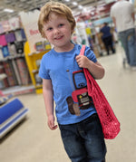 A child carrying the Turtle Bags kids size organic cotton string produce net bag