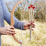 A close up of a child's hand folding the bow and arrows from the Vah Easy Aim Bow with Safety Arrows Set.