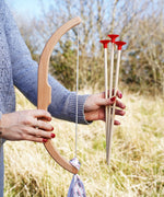 A close up of a child's hand folding the bow and arrows from the Vah Easy Aim Bow with Safety Arrows Set.