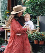 A woman carrying her baby with the Wildride stylish hip sling carrier for toddlers, in a Boho print