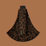 Wildride toddler carrier in brown leopard. A 100% cotton seat stylish hip carrier for babies showing the strap folded over the carrier seat.
