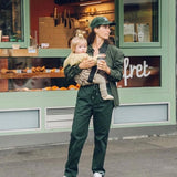A woman carrying her toddler in the Wildride carrier, in a brown zebra print