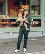 A woman carrying her toddler in the Wildride carrier, in a brown zebra print