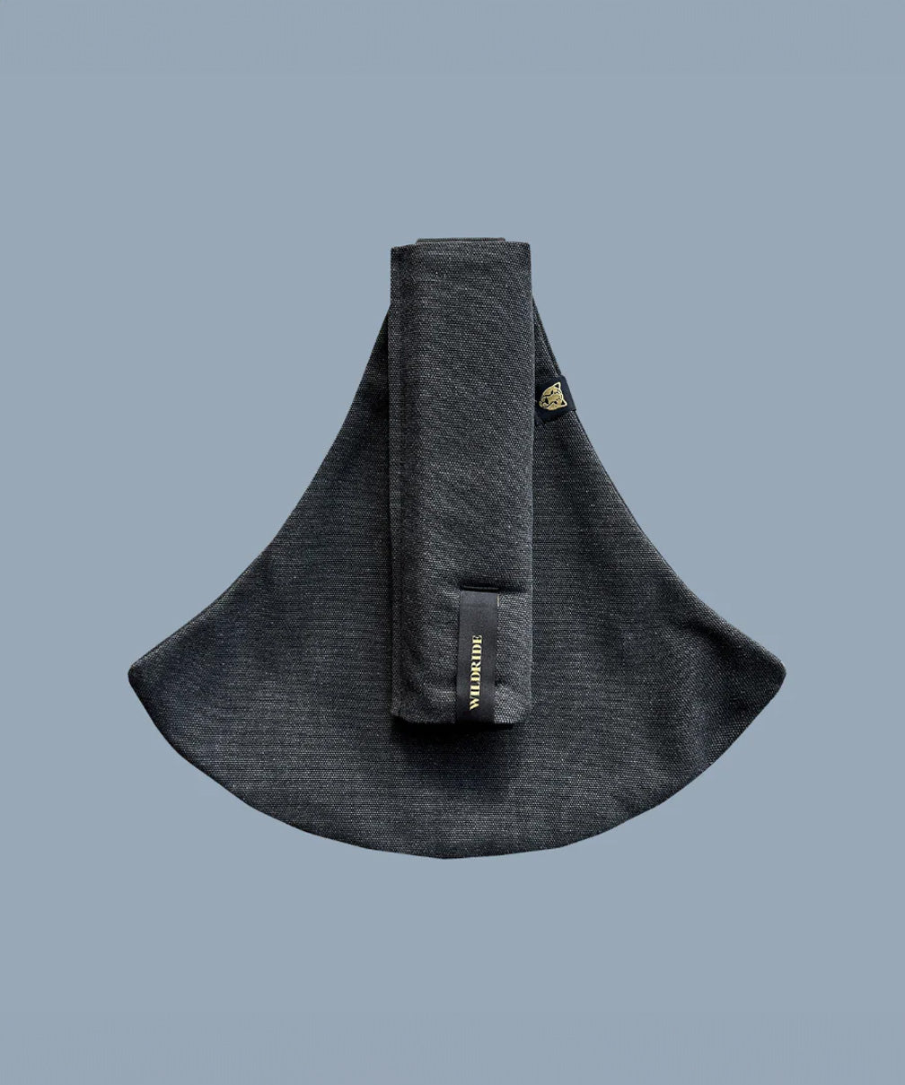 Wildride toddler carrier in graphite grey. A 100% cotton seat stylish hip carrier for babies with brand name on the strap that's folded over the carrier's seat
