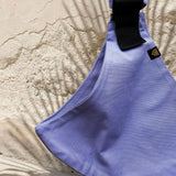 A close up of the Wildride lavender toddler  carrier showing the strap details between the seat.