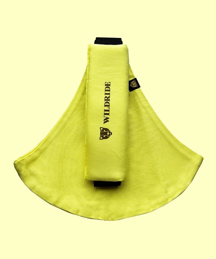 Wildride toddler carrier in lemon yellow. A 100% cotton seat stylish hip carrier for babies with brand name on the strap that's folded over the carrier's seat