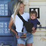 A woman carrying her baby in the stylish Wildride hip sling carrier in grey leopard print
