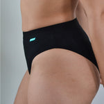 Close up of a woman wearing the WUKA tencel bikini brief underwear on a grey background