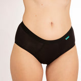 Close up of woman wearing the WUKA eco-friendly midi brief everyday pants on a white background