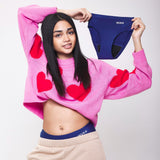 worn by a model. An image of four white 'drops' indicates these pants are suitable for a heavy flow.