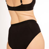 Close up of woman wearing the everyday WUKA midi brief eco-friendly pants on a white background