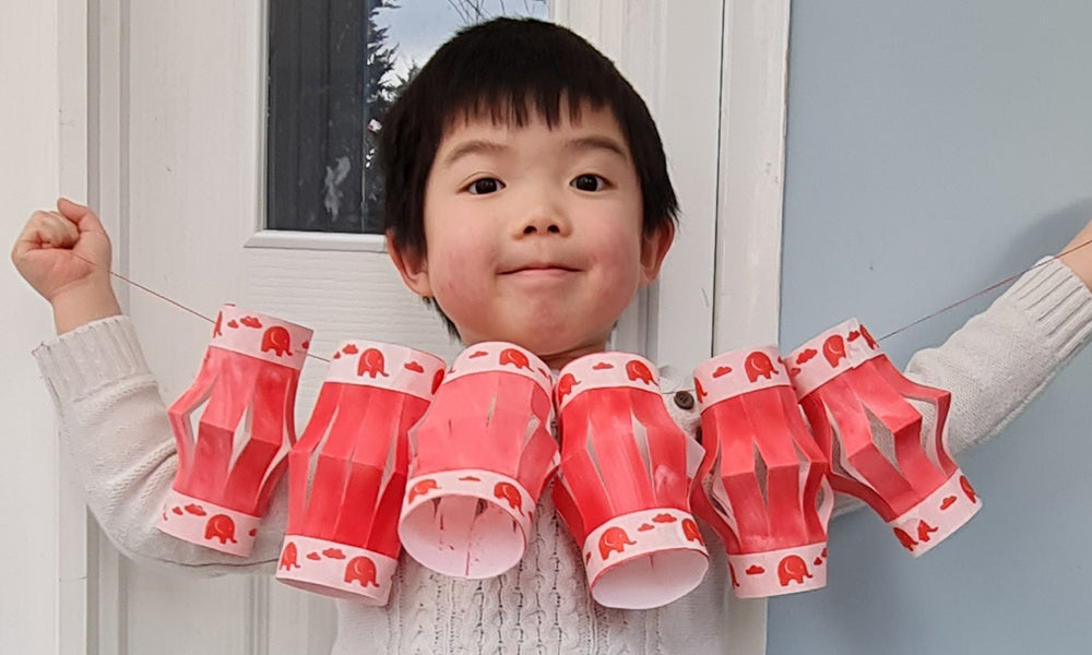 Child holding handmade paper Chinese lanterns to represent a 'preparing for lunar new year with Babipur' blog by Babipur.