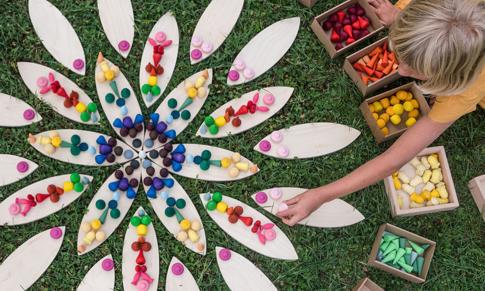 Child outside playing with Grapat Petal Platforms and colourful mandala pieces to represent a 'how to play with Grapat petals' blog by Babipur.