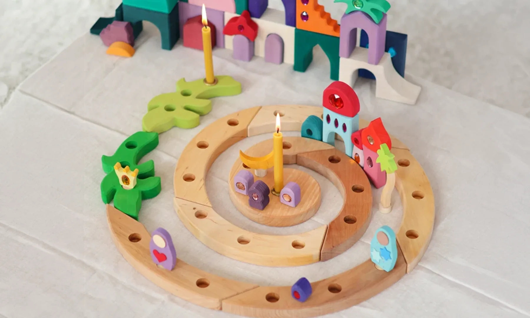 Grimm's natural spiral celebration ring decorated with candles and pieces from the Grimm's sparkling orient building set.