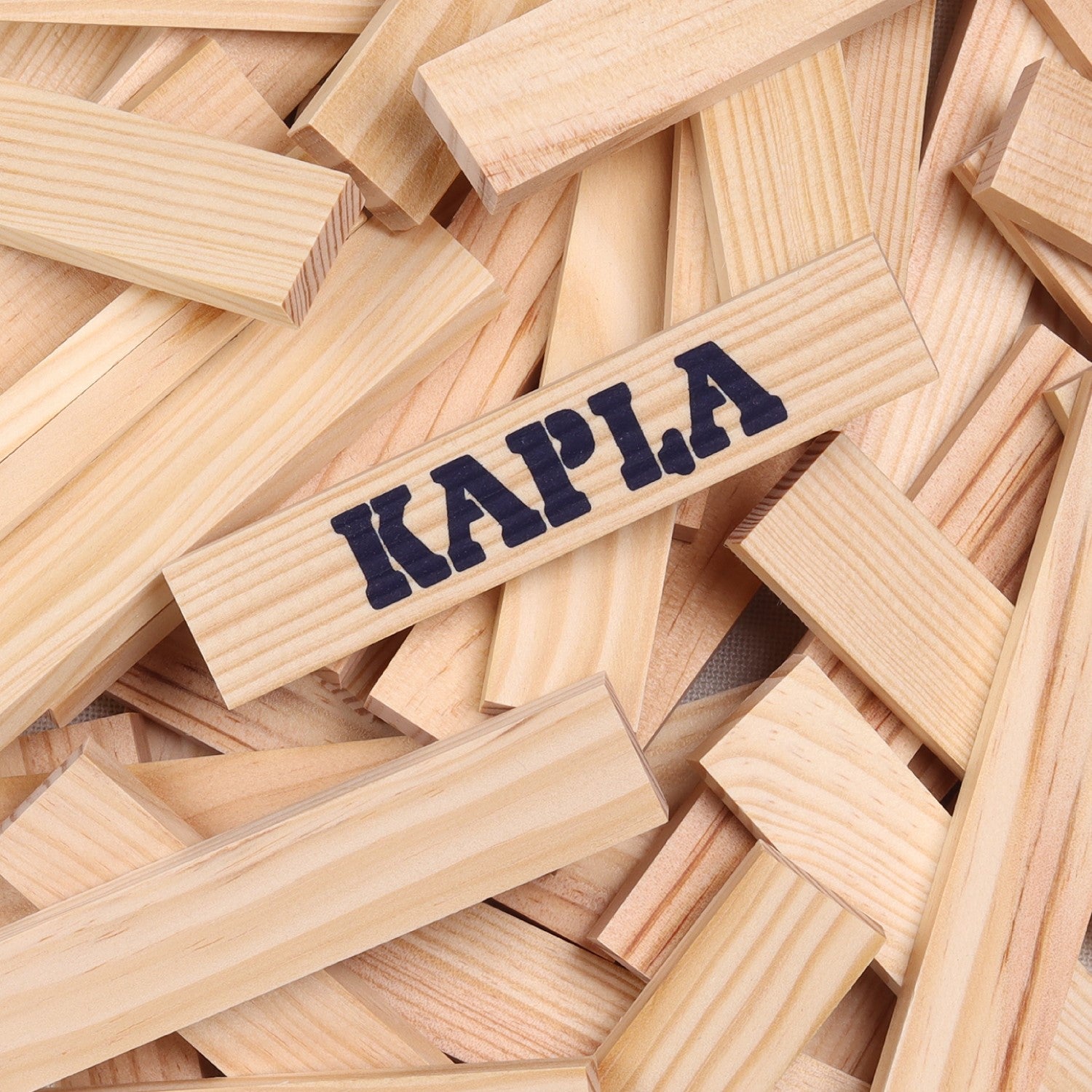 Kapla building blocks, natural pine wood blocks of a uniform shape and size. Central block branded with KAPLA