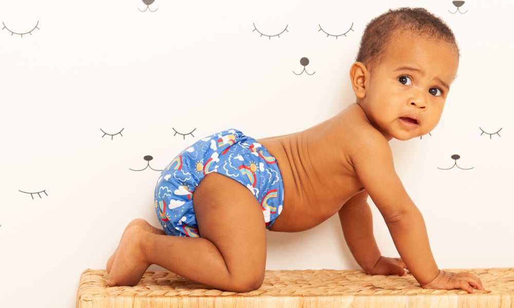 A baby crawling wearing a reusable TotsBots cloth nappy to represent a 'Beginners Guide to Reusable Nappies' blog by Babipur.