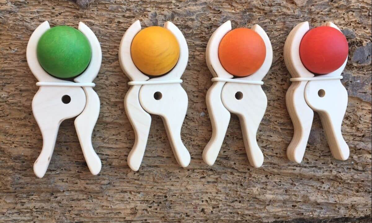 Four Speelbelovend giant wooden pegs holding green, yellow, orange and red wooden balls