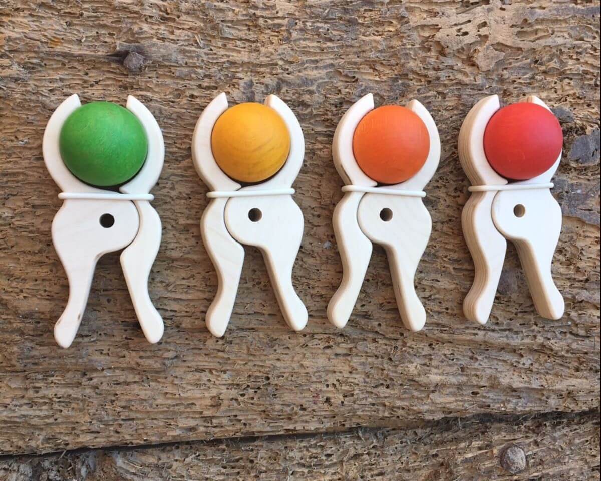 Four Speelbelovend giant wooden pegs holding green, yellow, orange and red wooden balls