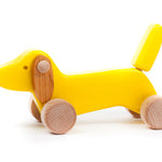Bajo handmade yellow wooden dachshund puppy toy on a white background