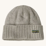 A grey beanie with the Patagonia logo on the front on a cream background