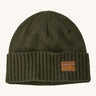 A green beanie with a Patagonia logo on the front on a cream background.