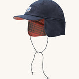 A blue Patagonia earflap cap with a check design on the inside with the flaps down.