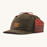 A brown cord Patagonia earflap cap with a red check design on the inside on a cream background.