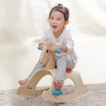 A child rocking on the PlanToys Palomino Rocking Horse. 