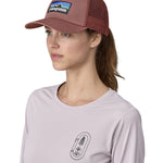 A female adult wearing the pink Patagonia trucker hat