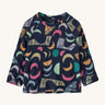 A navy fleece sweater with different coloured shapes on a cream background