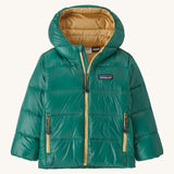 Green kids down Patagonia coat with gold trim on a cream background