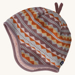 A light coloured reversible beanie with a diamond design on a cream background.