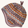 A light coloured reversible beanie with a diamond design on a cream background.