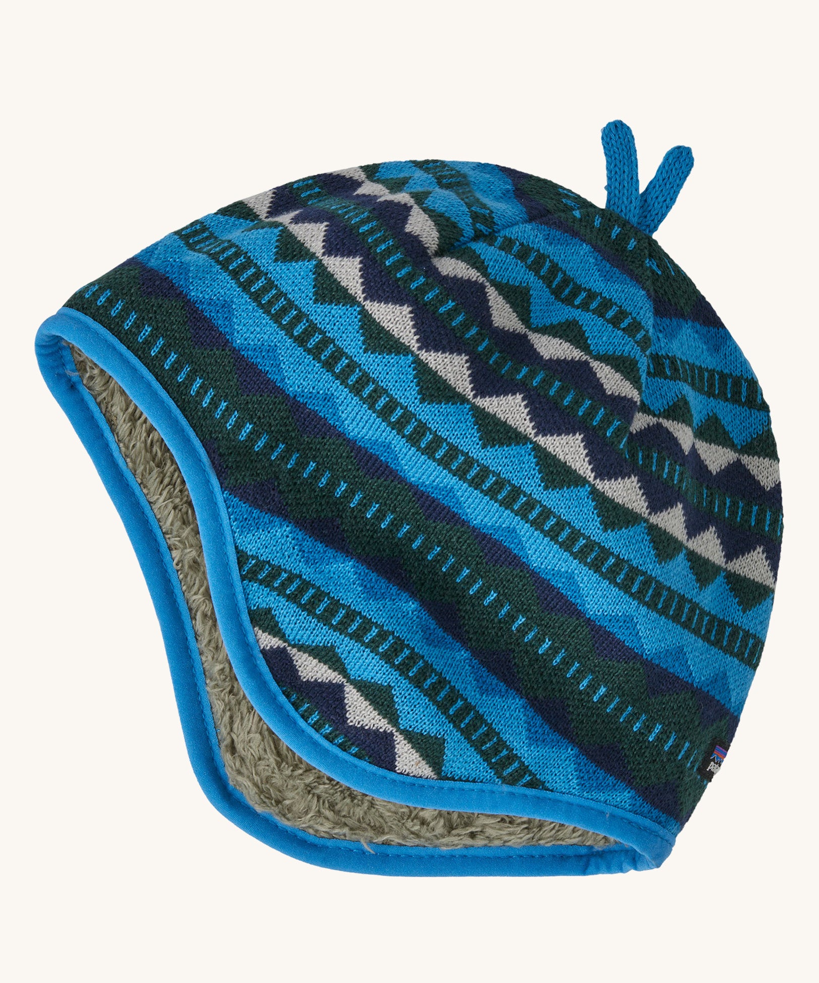 A blue reversible beanie with diamond patterns on a cream background